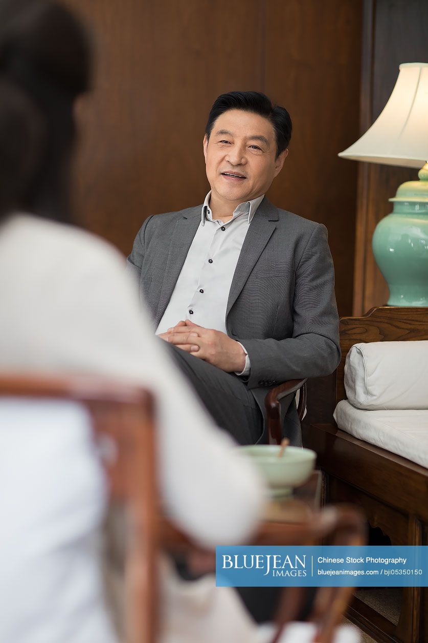 Cheerful Chinese businessman talking with a woman