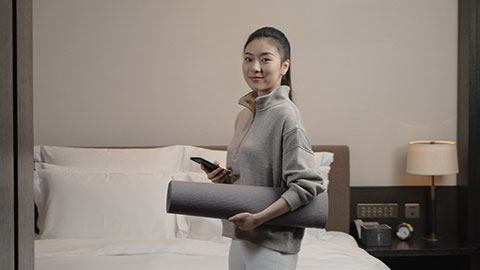 Young Chinese woman holding yoga mat and smartphone,4K
