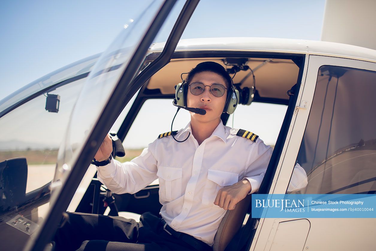 Chinese pilot sitting in helicopter cockpit
