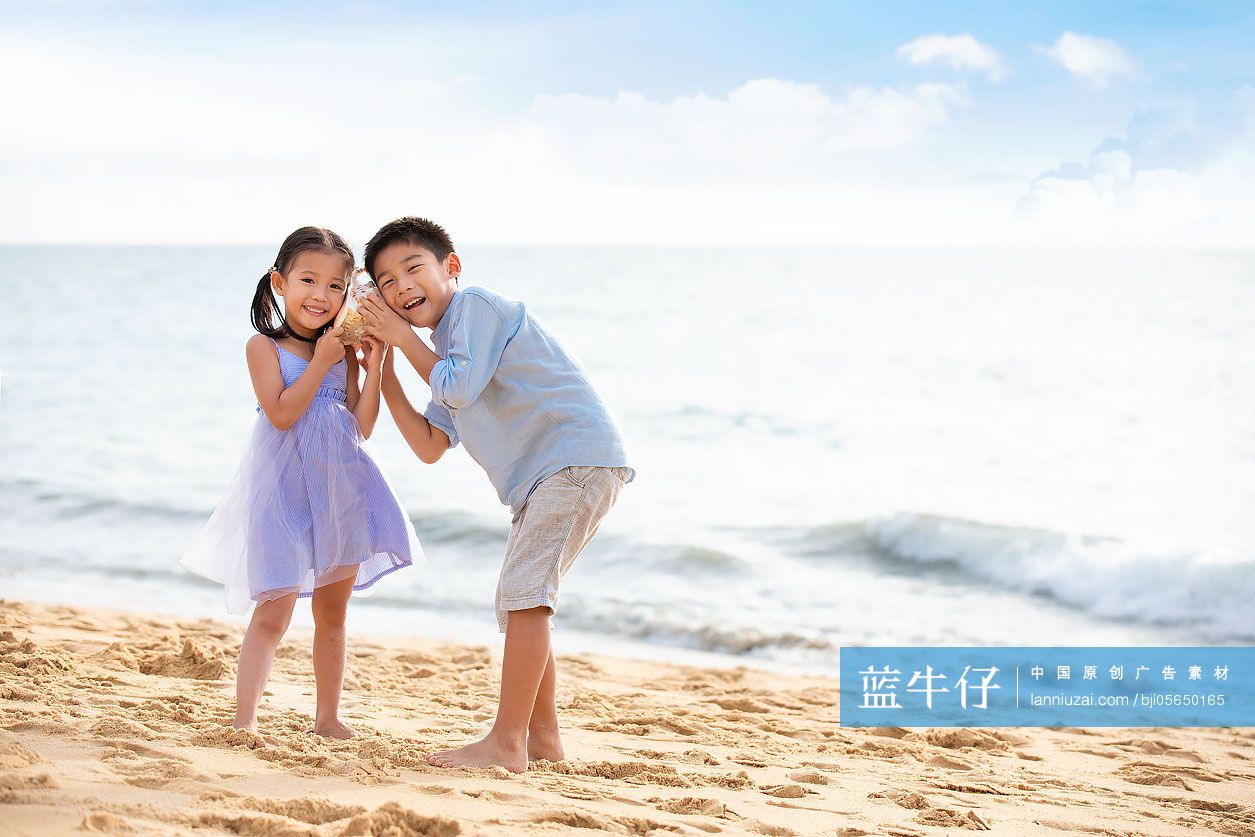 兄妹俩在沙滩听海螺