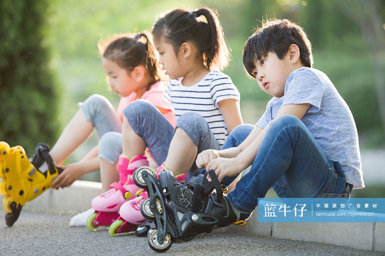 儿童坐在路边穿直排轮鞋