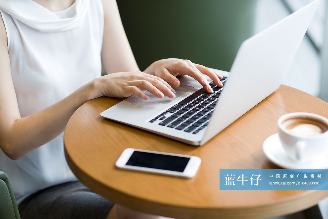 年轻女士在咖啡厅使用笔记本电脑工作