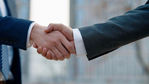 Confident Chinese businessmen shaking hands outdoors