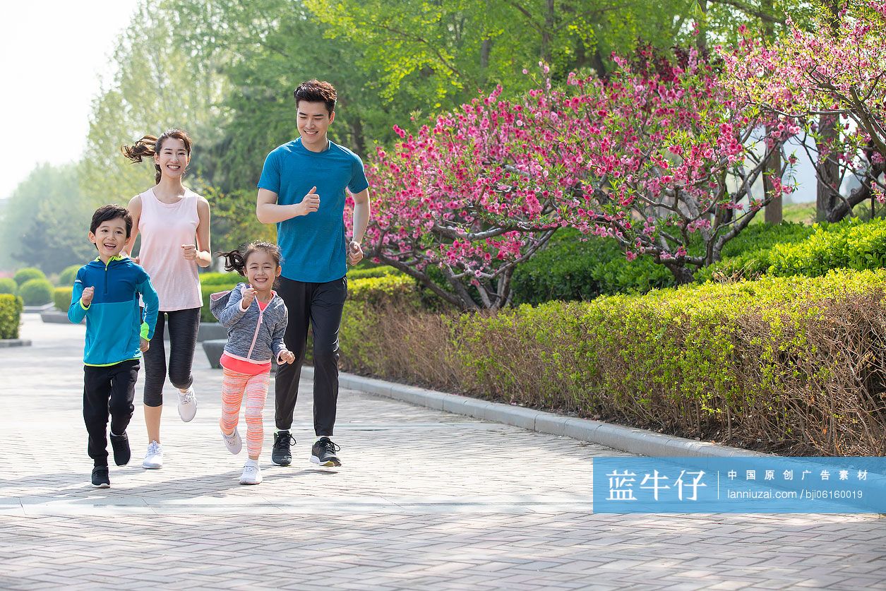 快乐的年轻家庭在公园跑步