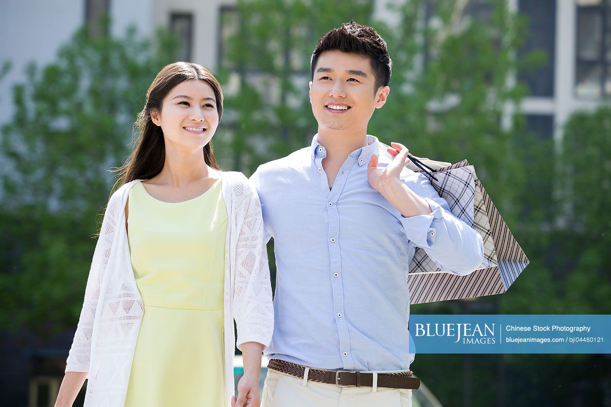 Happy young Chinese couple shopping