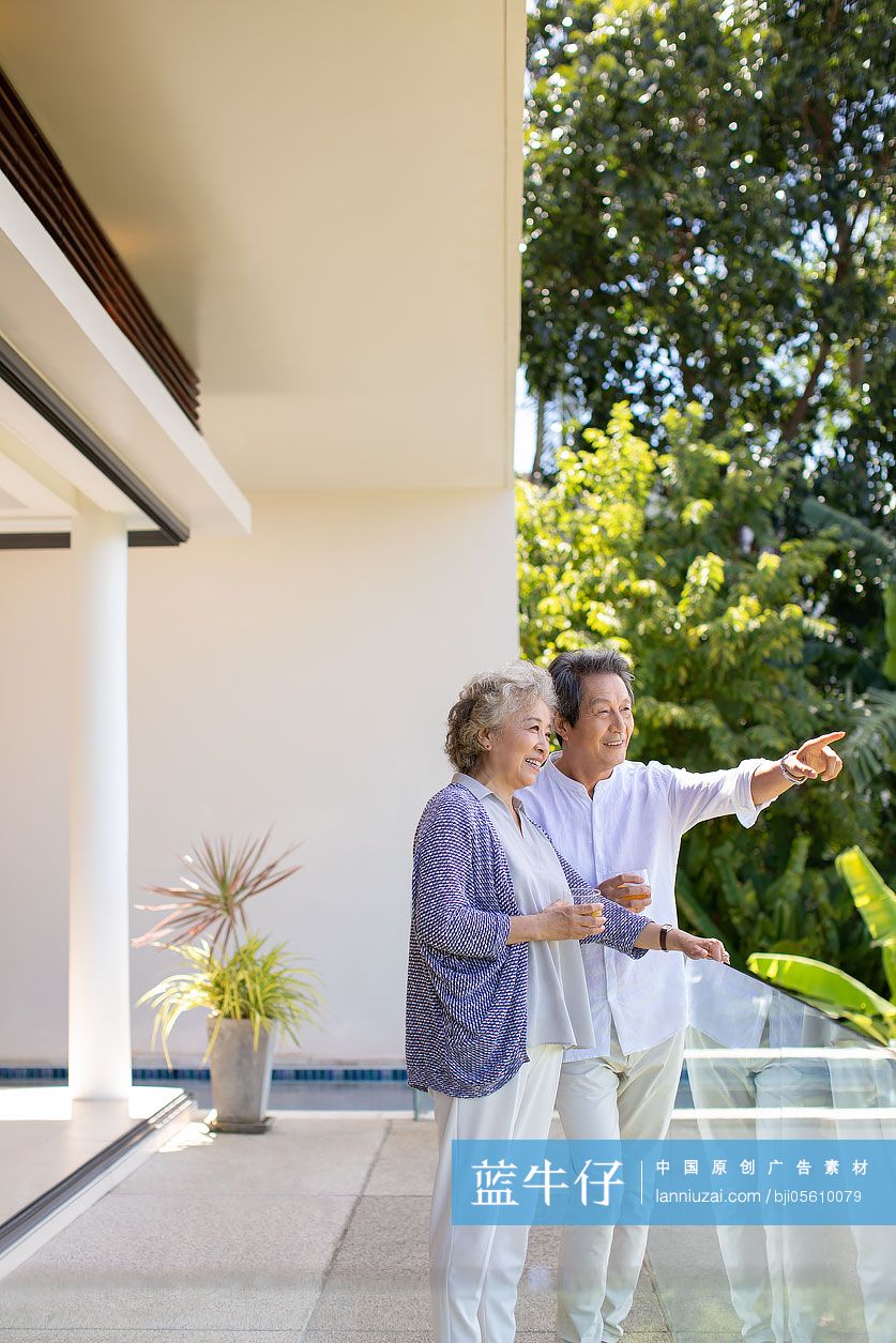 快乐的老年夫妇在阳台喝酒
