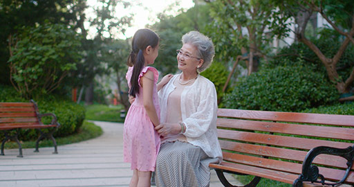 Happy Chinese grandmother and granddaughter relaxing in park,4K