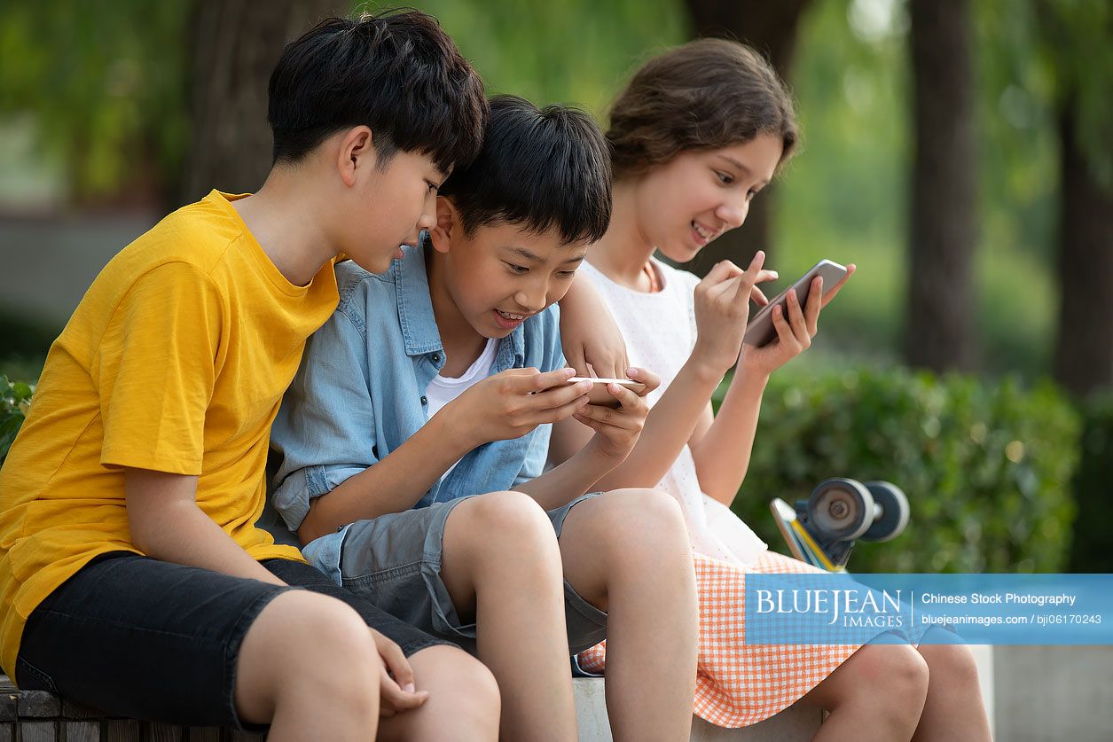 Teenagers using smartphone outdoors