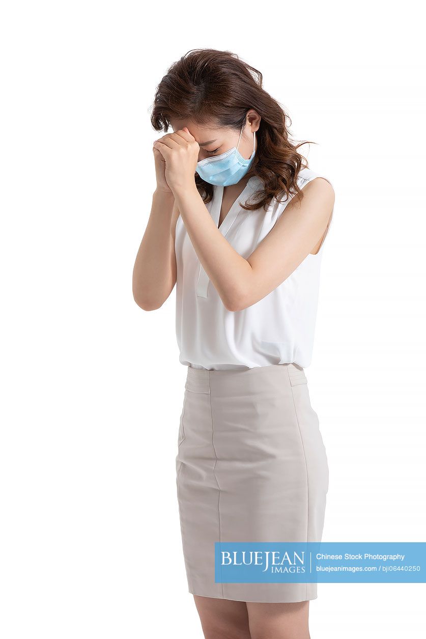 Young Chinese businesswoman with surgical mask praying