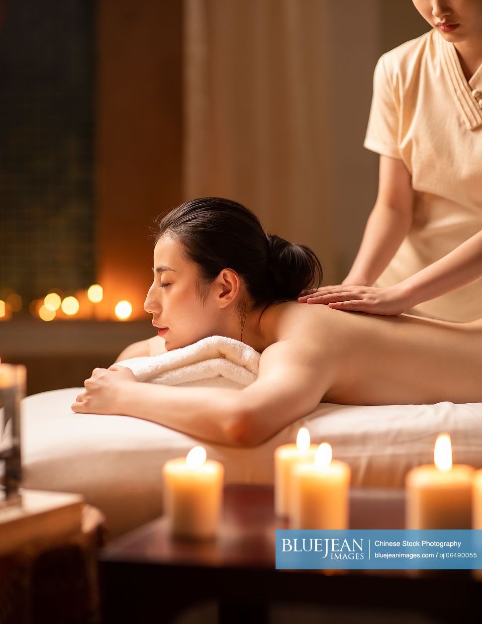 Young woman receiving a back massage in a spa center stock photo