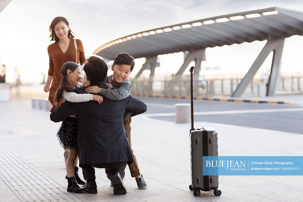 Happy young Chinese family at airport