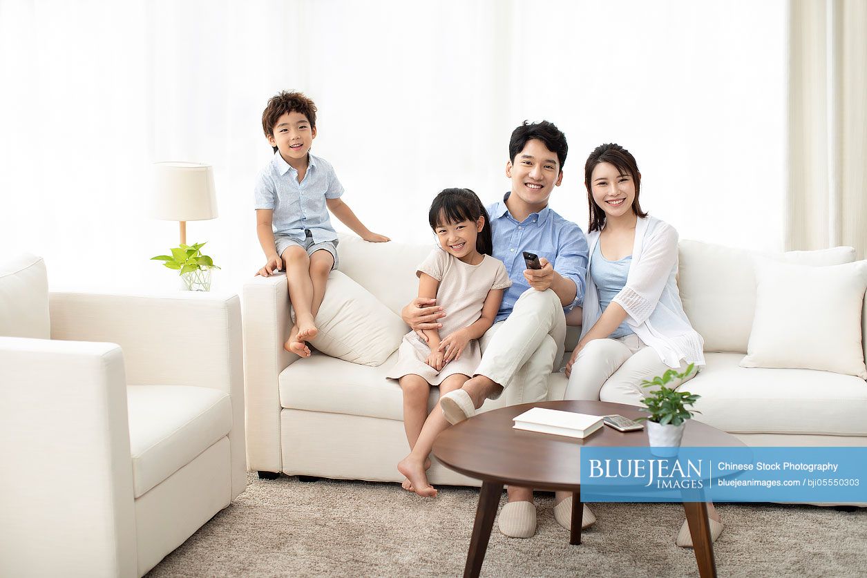 Happy young family watching TV at home