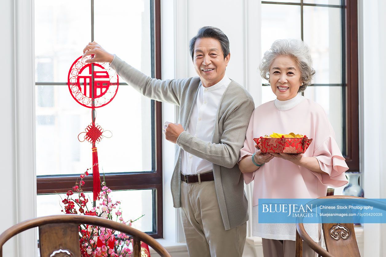 Senior couple decorating their house for Chinese New Year