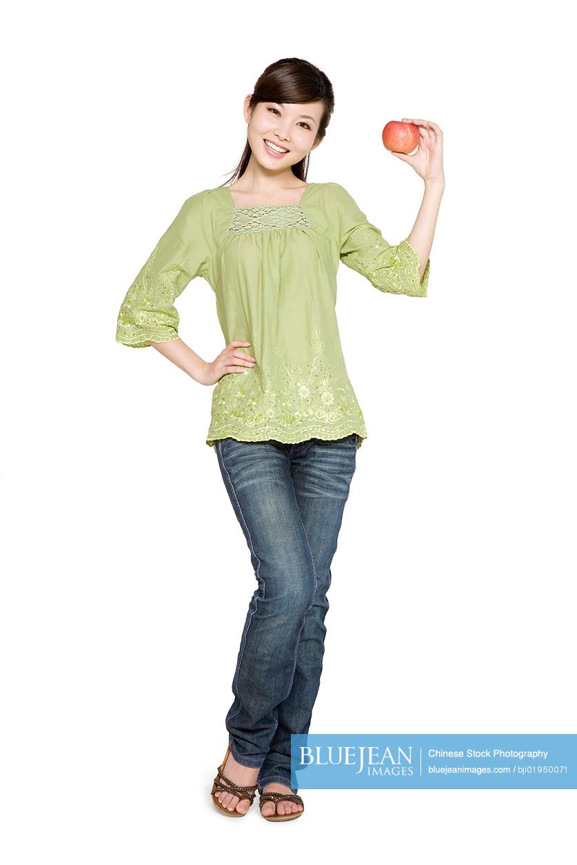 Portrait of young Chinese woman with red apple