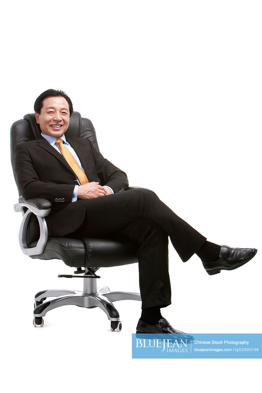 Senior Chinese businessman sitting on director's chair