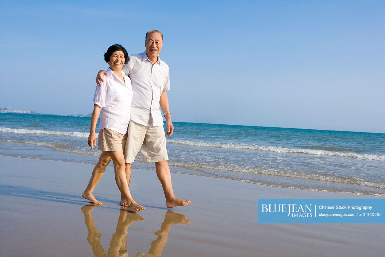 Senior Chinese couple walking along the beach-High-res stock photo for ...