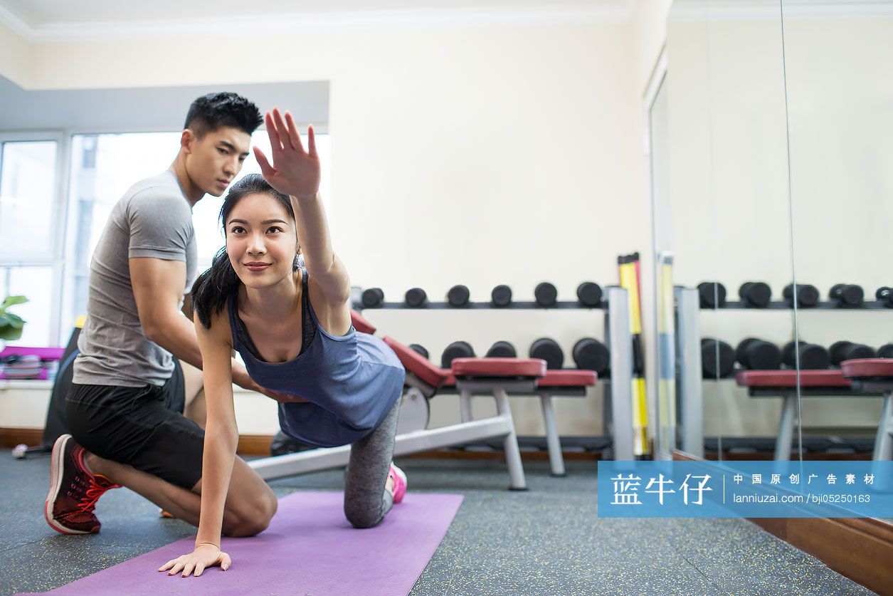年轻女子在教练的指导下健身