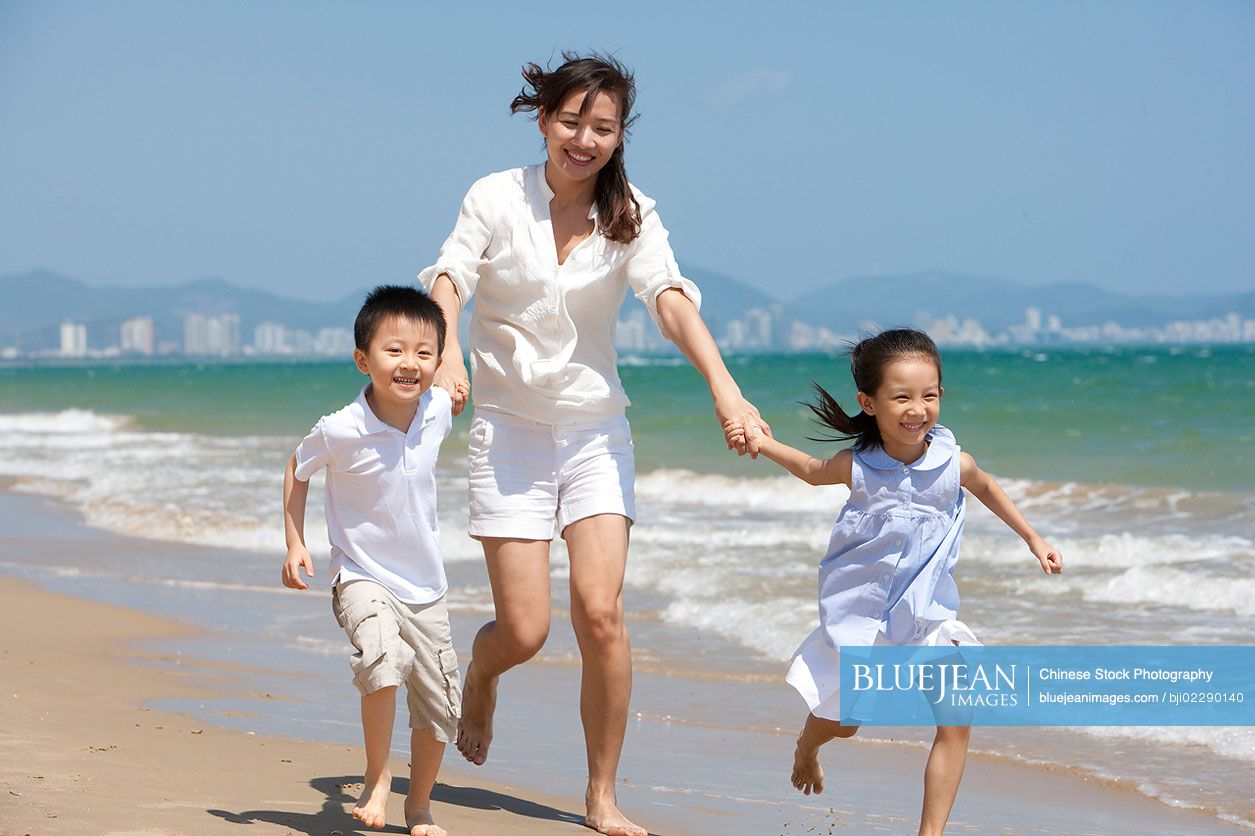 Chinese family running on the beach