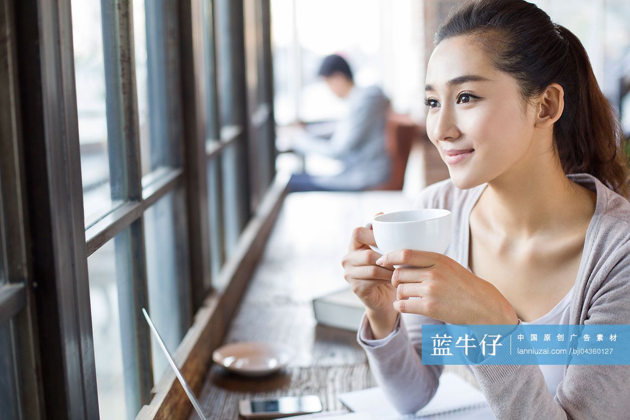 年轻女子在咖啡馆喝咖啡