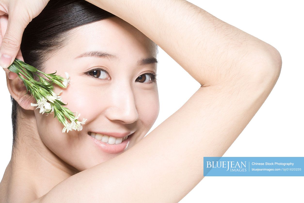 Young Chinese woman holding small flowers