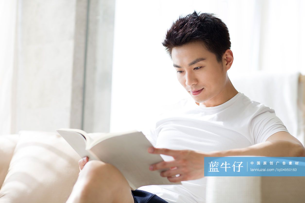 年轻男子在沙发上看书