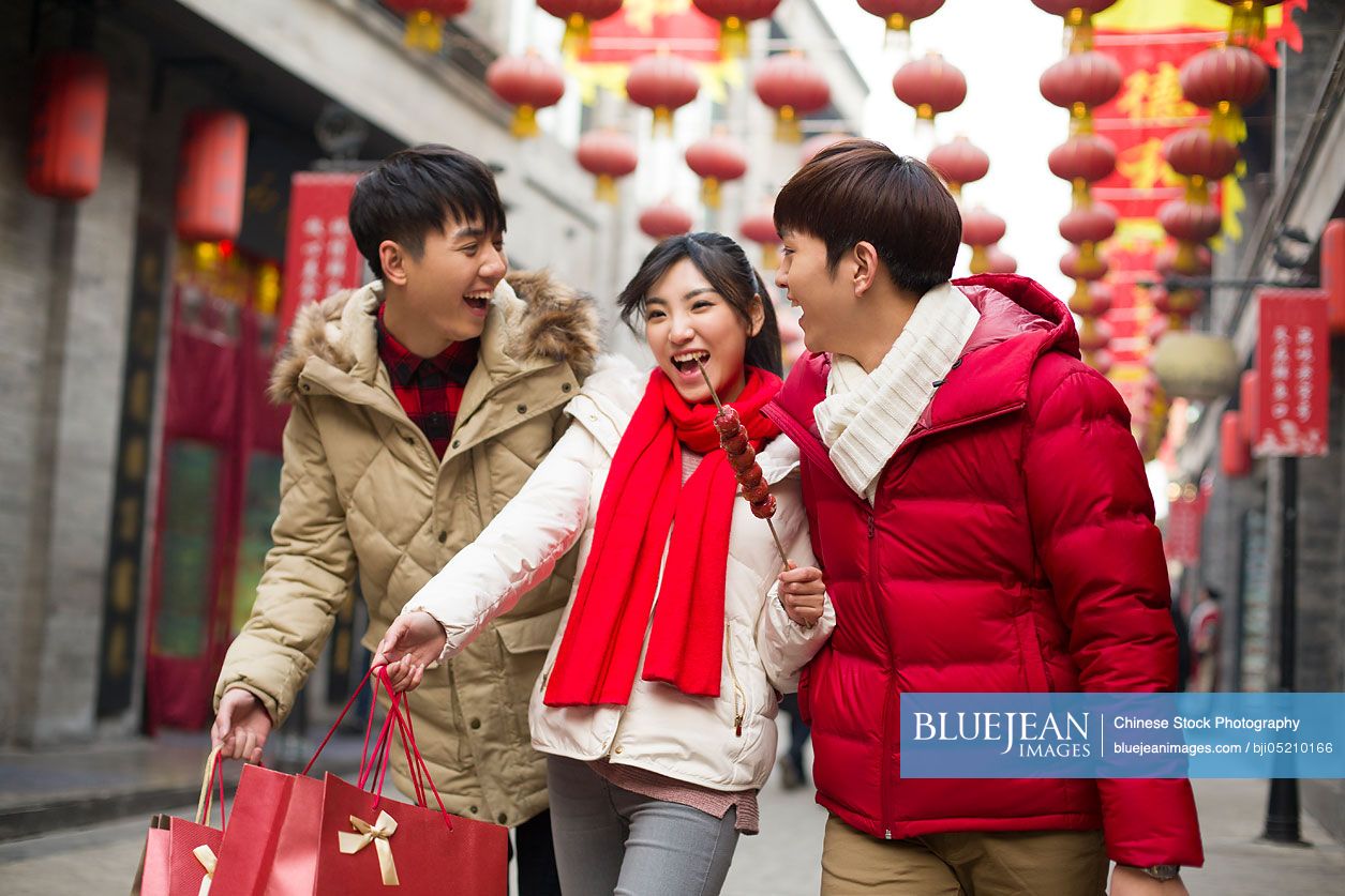 Happy young Chinese friends shopping for Chinese New Year