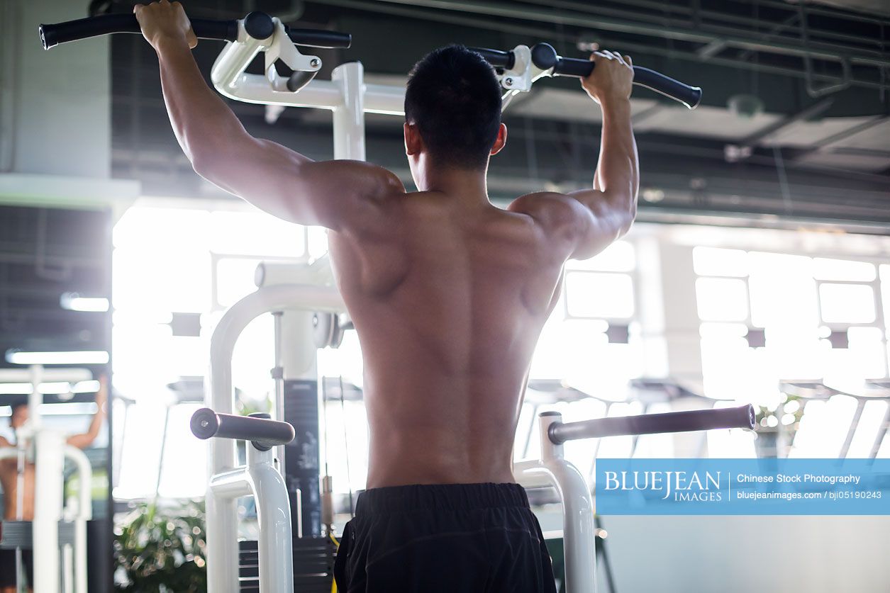 Young Chinese man exercising at gym