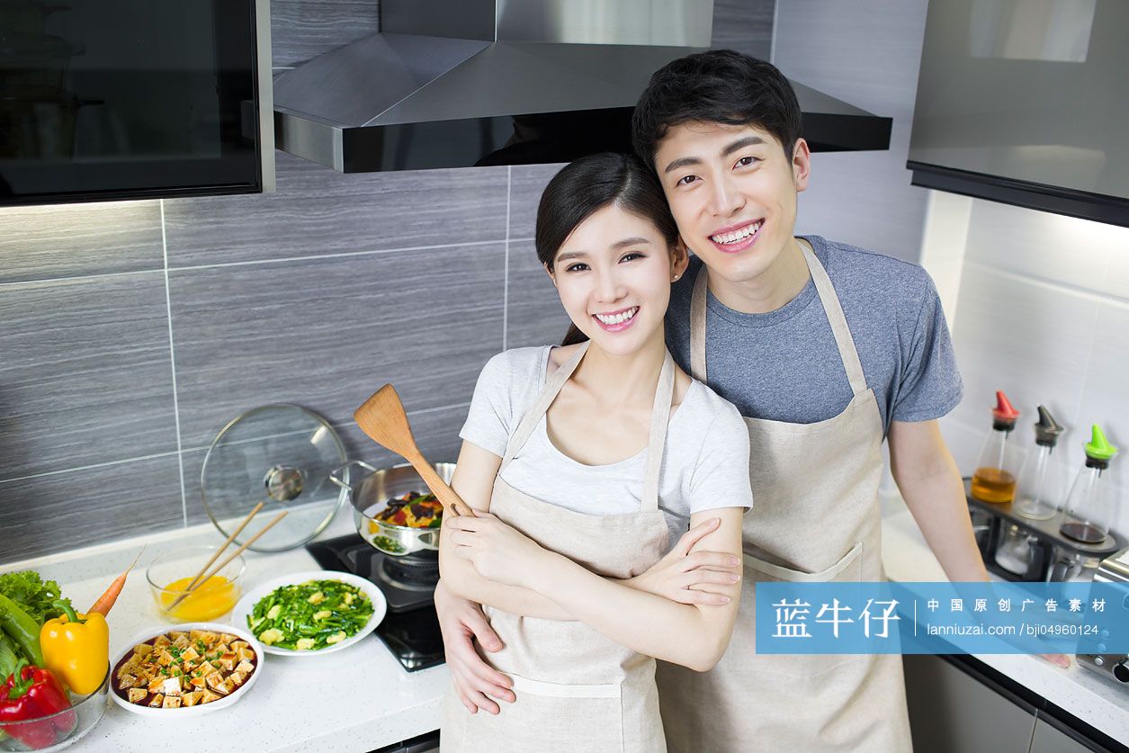 快乐的年轻夫妇在厨房做饭