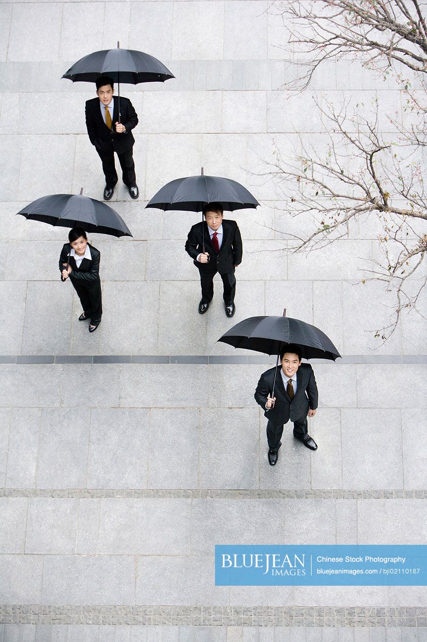 Chinese businessmen with umbrellas