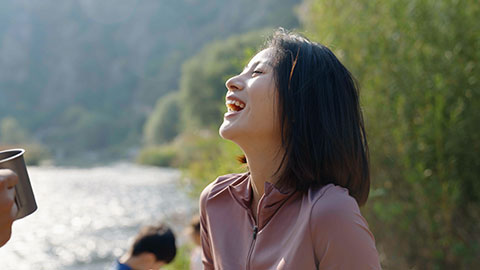 Happy young Chinese family camping outdoors