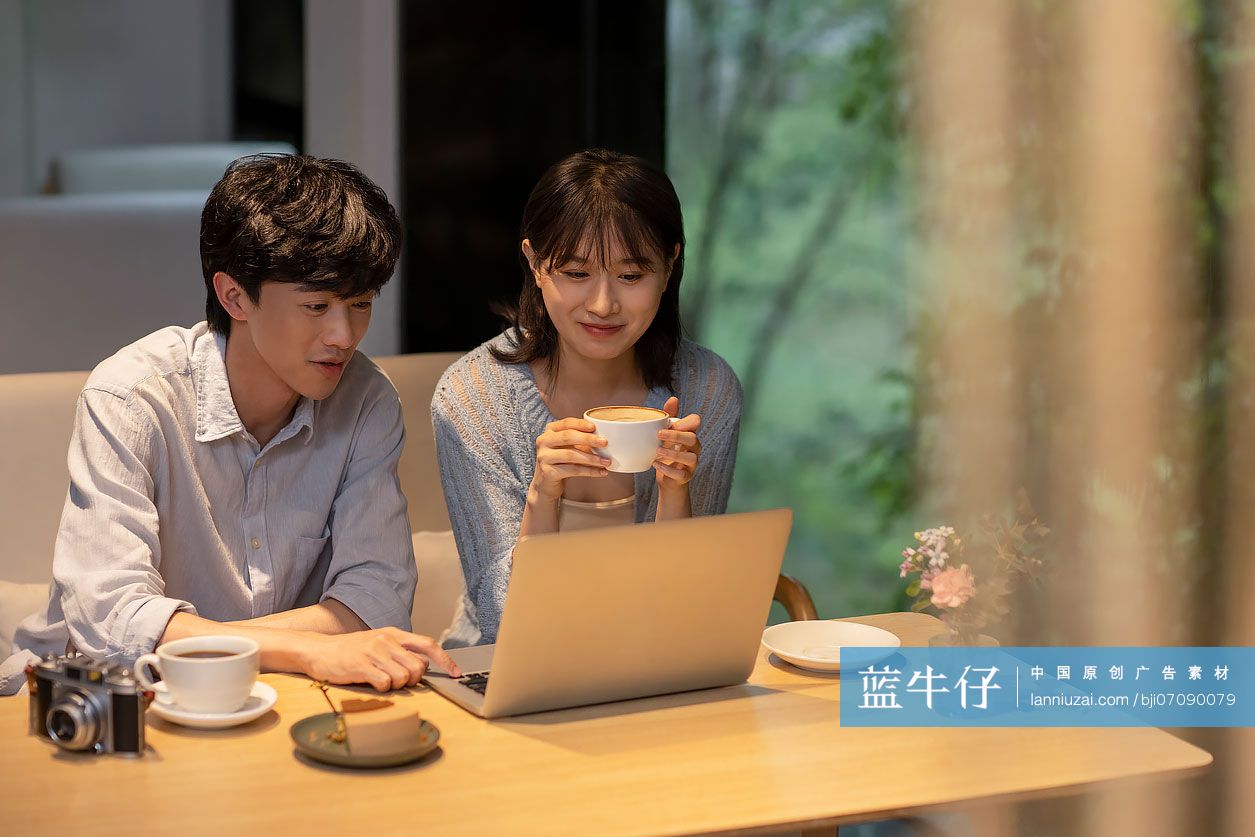 年轻情侣在咖啡馆使用笔记本电脑-蓝牛仔影像-中国原创广告影像素材