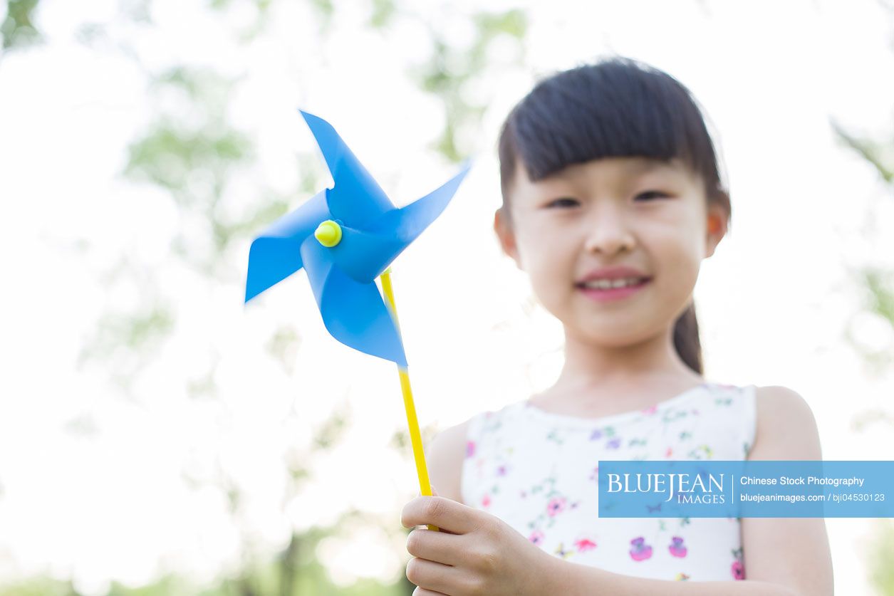 Happy Chinese girl holding a pinwheel