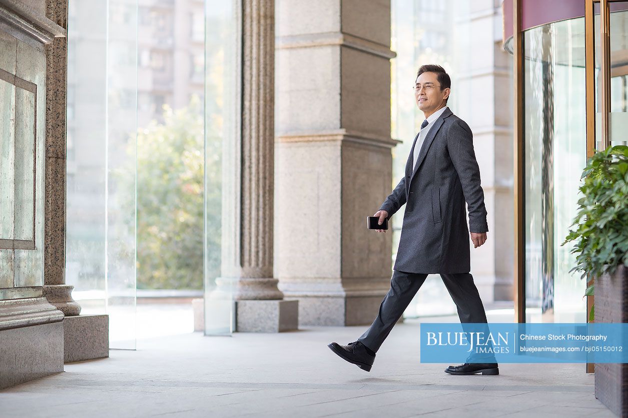 Confident Chinese businessman walking