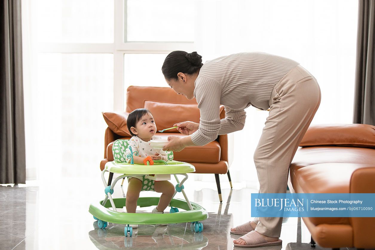 Happy Chinese grandmother taking care of baby girl