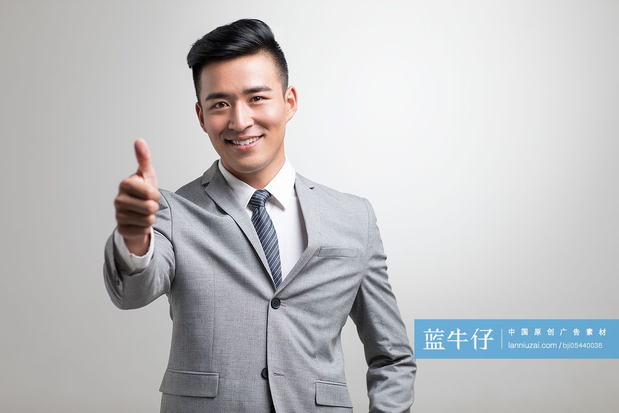 自信的年轻商务男子竖起大拇指
