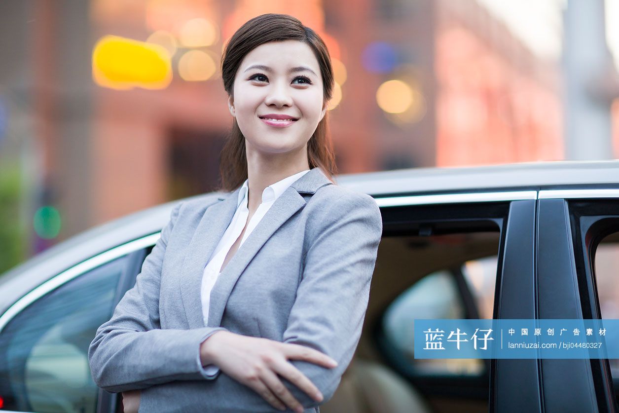 商务女士站在汽车旁边