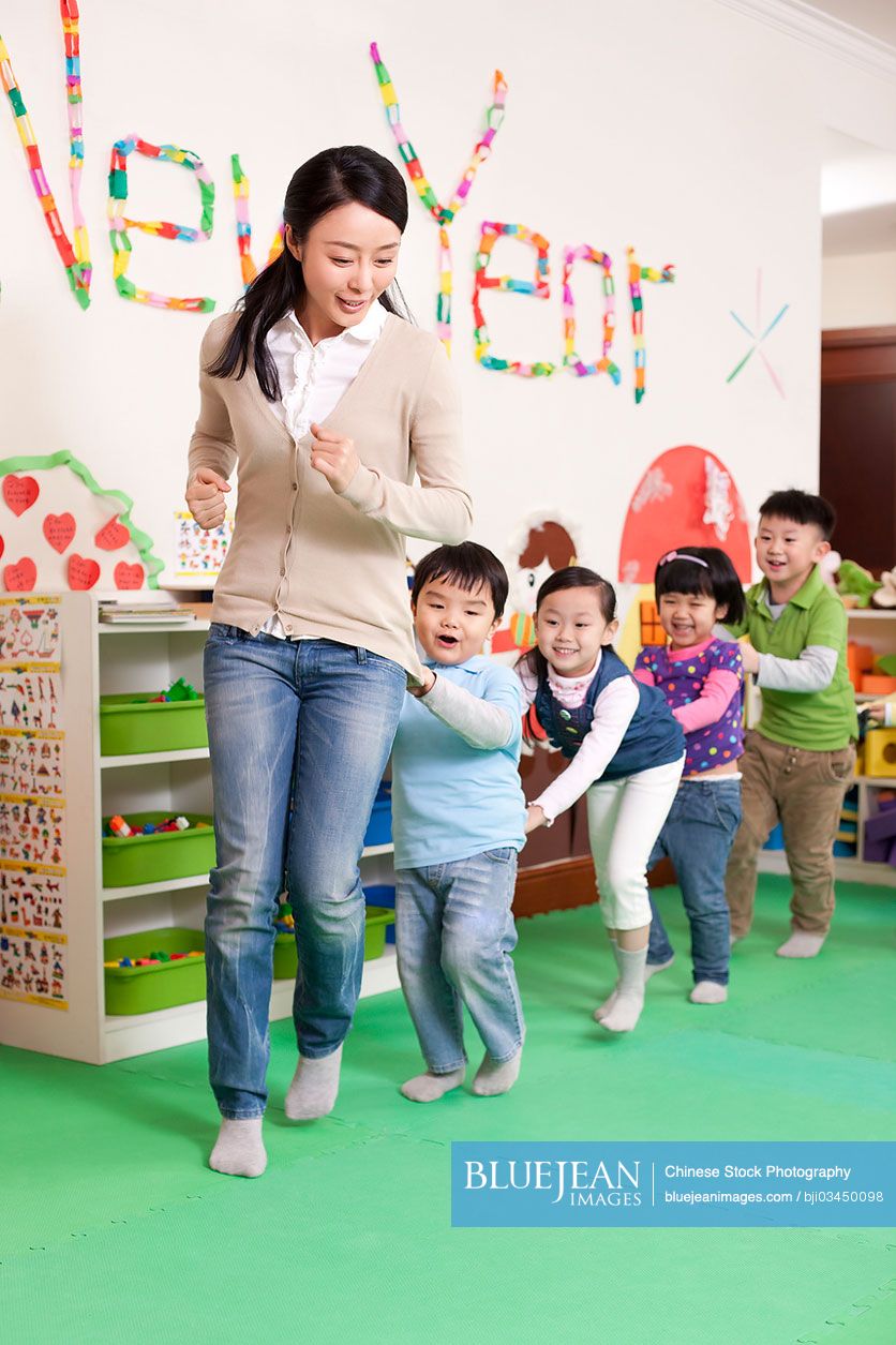 Happy Chinese kindergarten children and teachers playing games