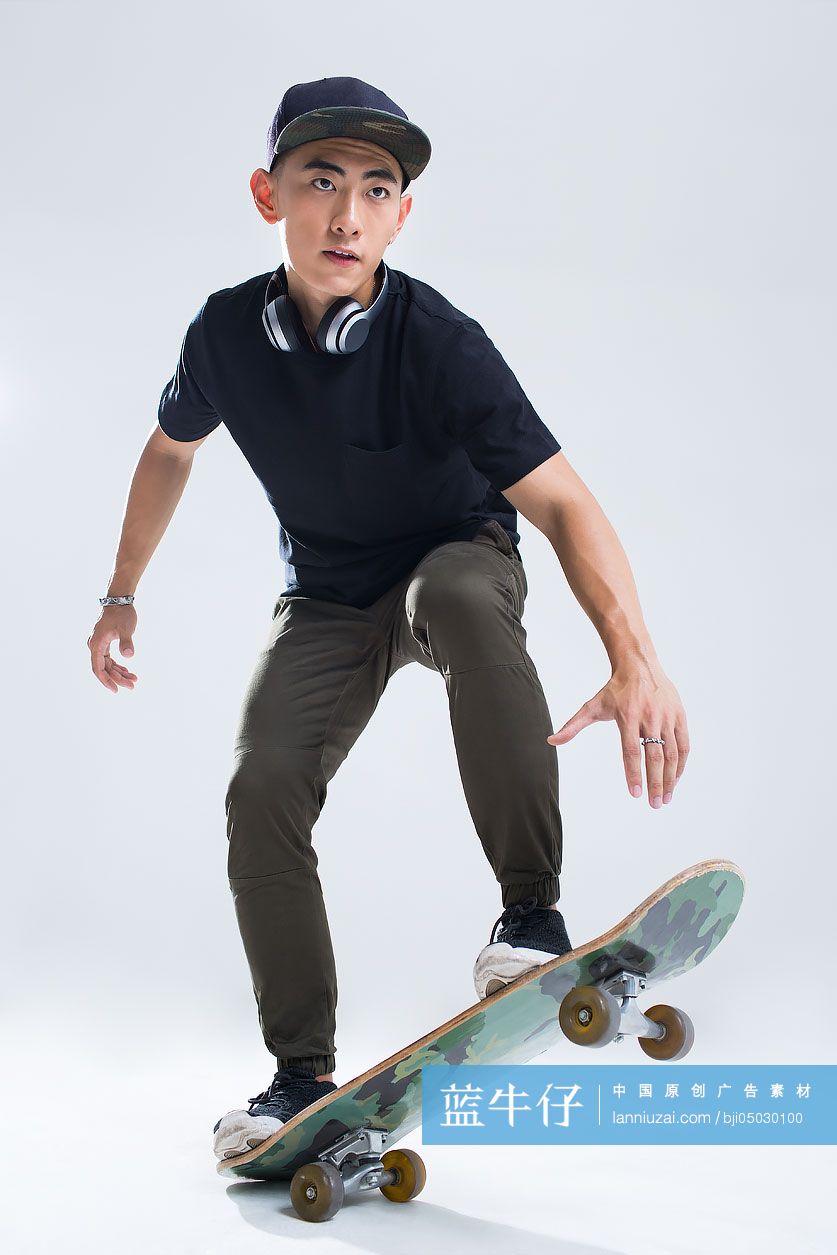 戴耳机的年轻男子在滑滑板