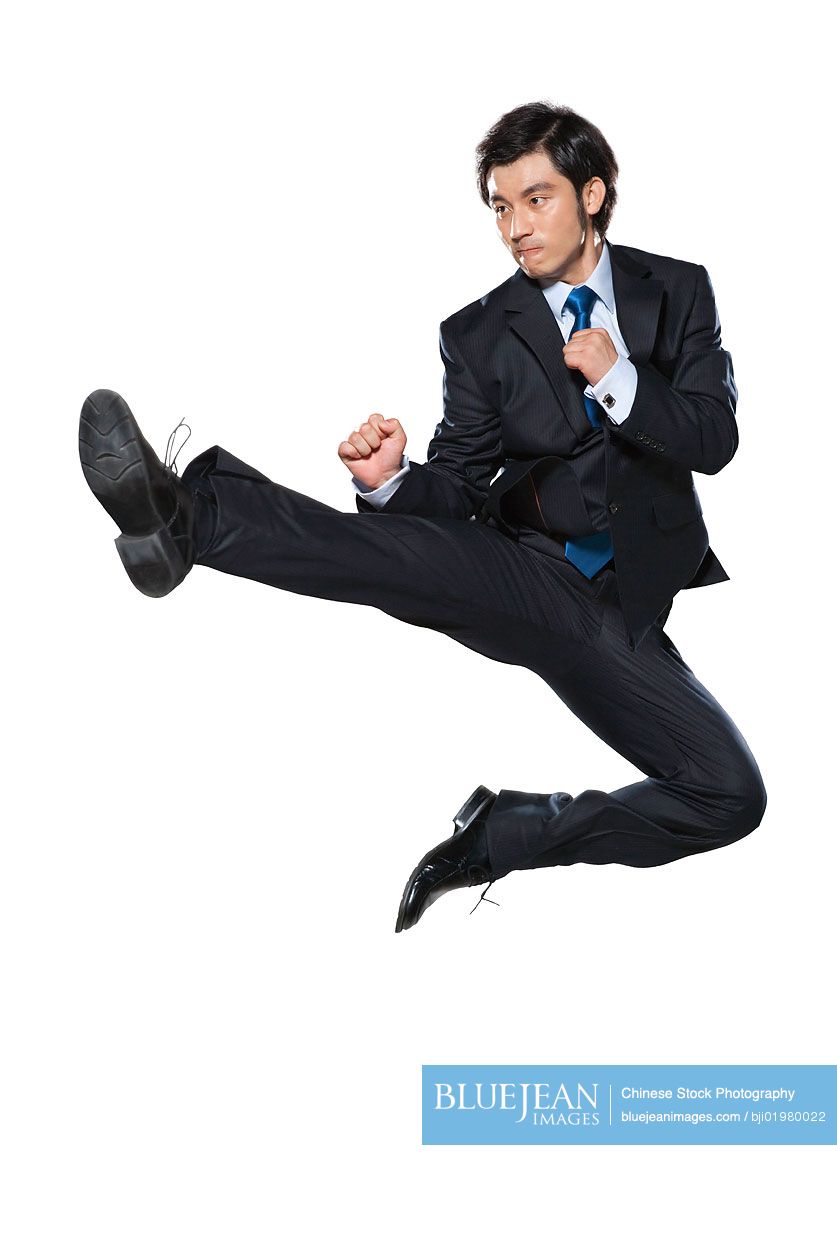 Chinese businessman doing a karate kick