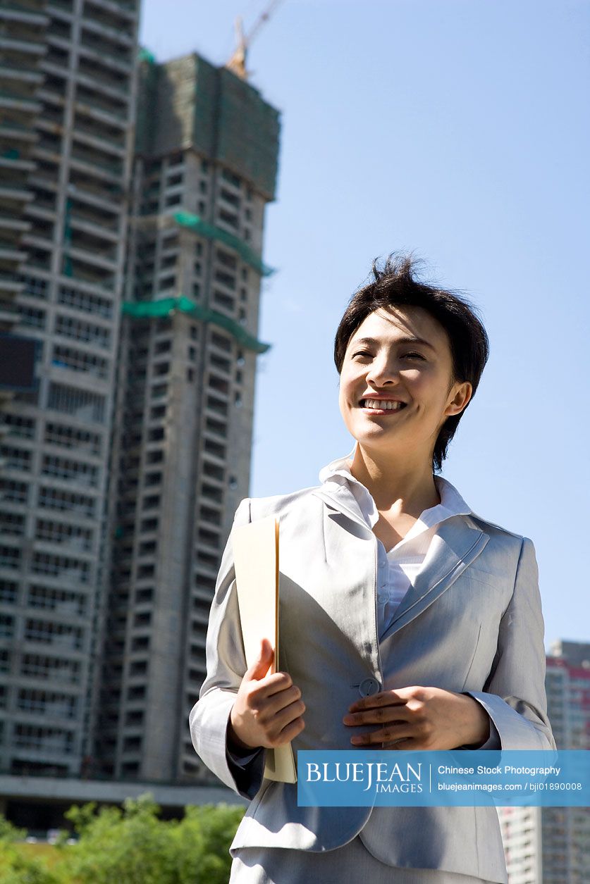 Chinese businesswoman in front of a building under construction