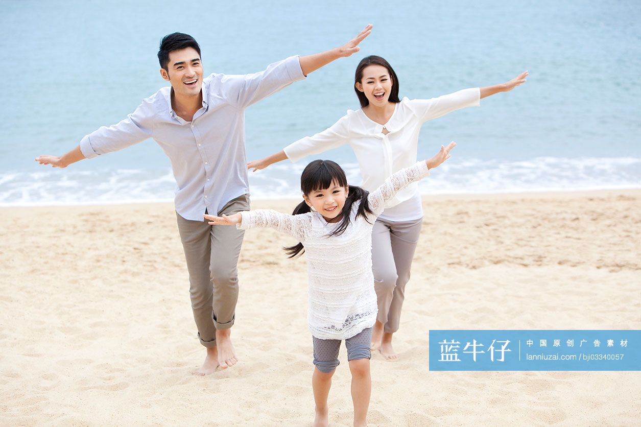 快乐的一家三口在沙滩上玩耍