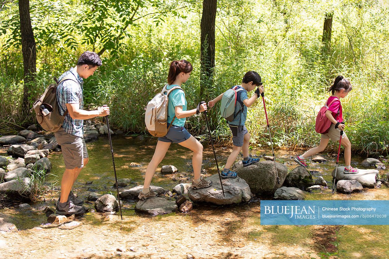 Happy young Chinese family hiking outdoors