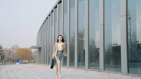 Confident Chinese businesswoman walking with a cup of coffee