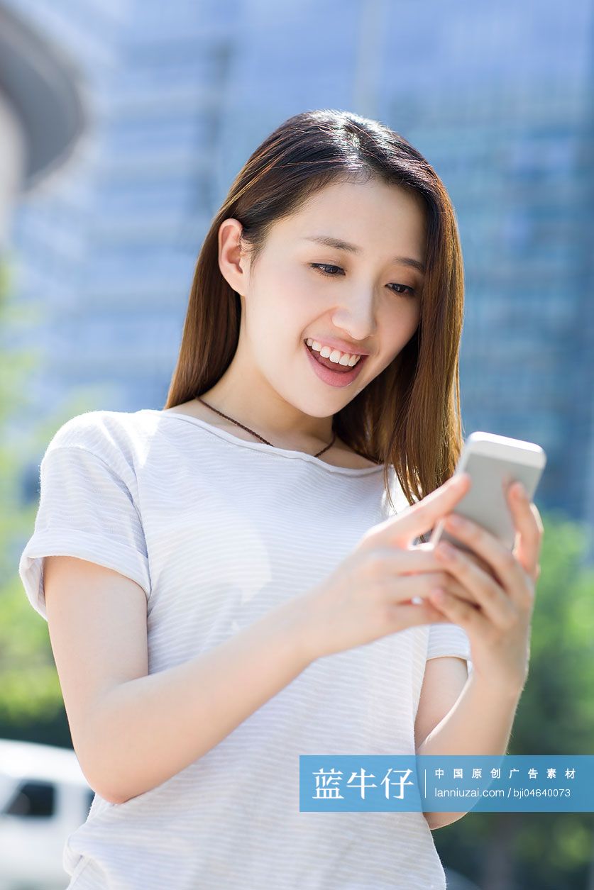 快乐的年轻女子使用手机