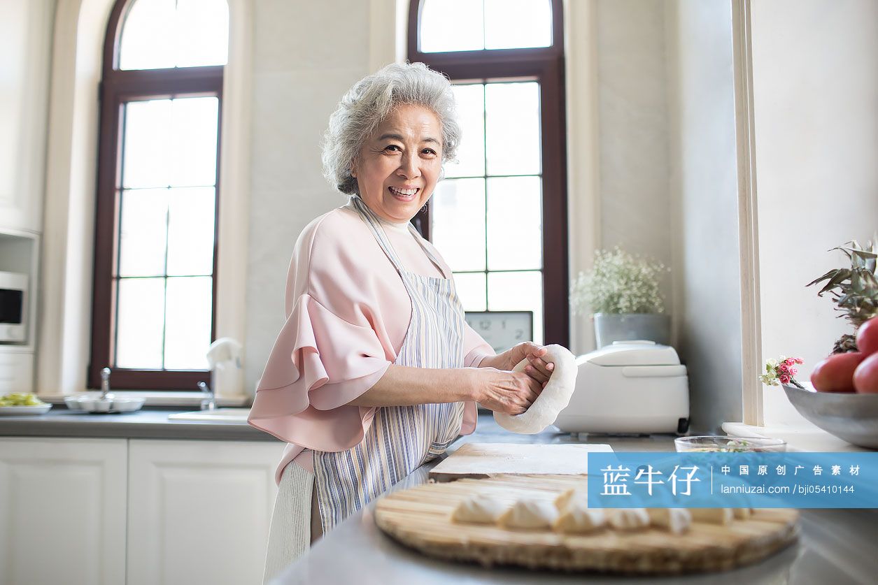 快乐的老年女子在厨房包饺子