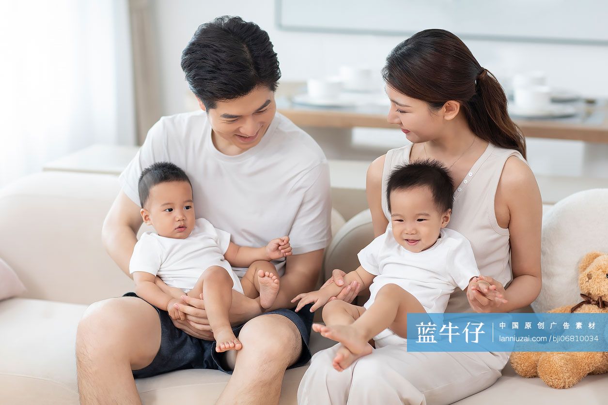 年轻父母在家陪龙凤胎宝宝玩耍