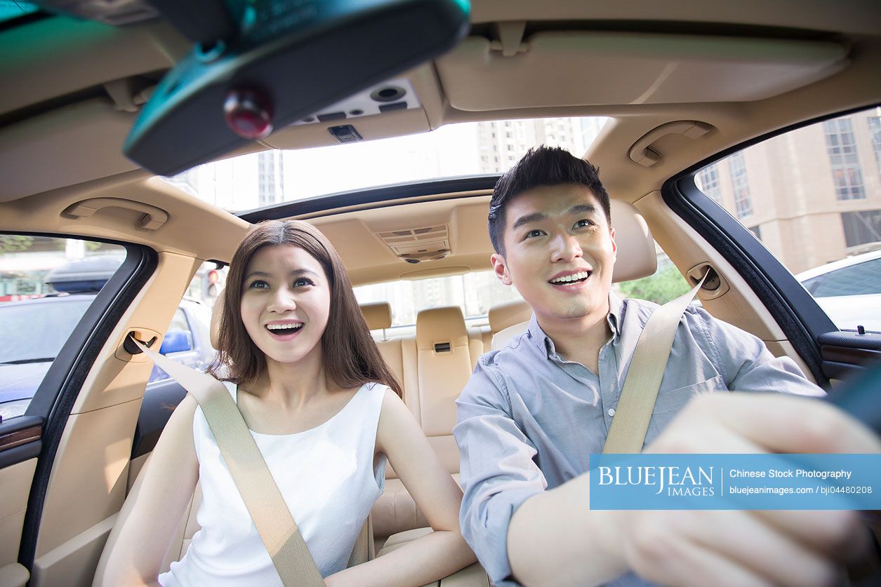 Happy young Chinese couple in a car