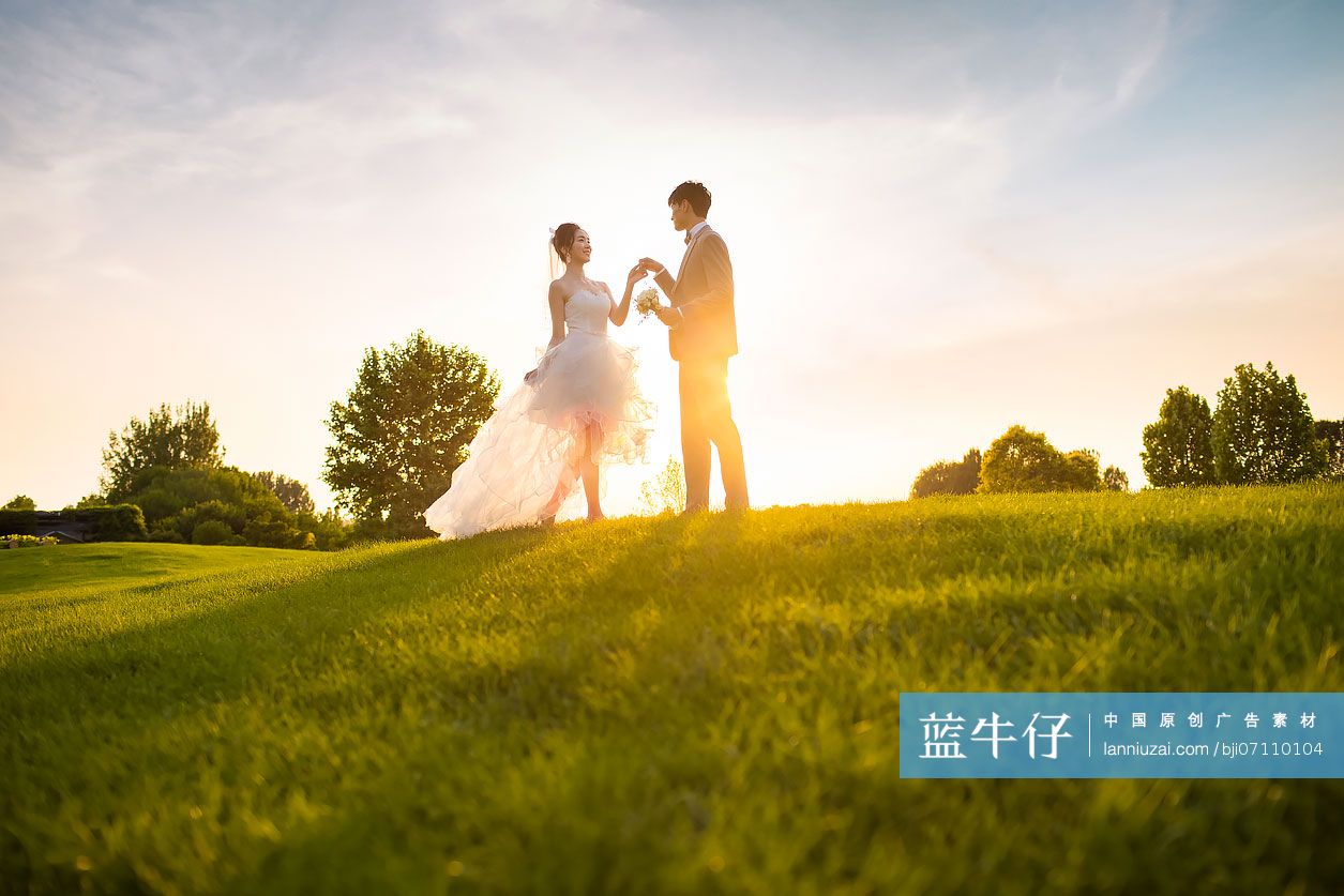 快乐的新郎新娘在草地上跳舞