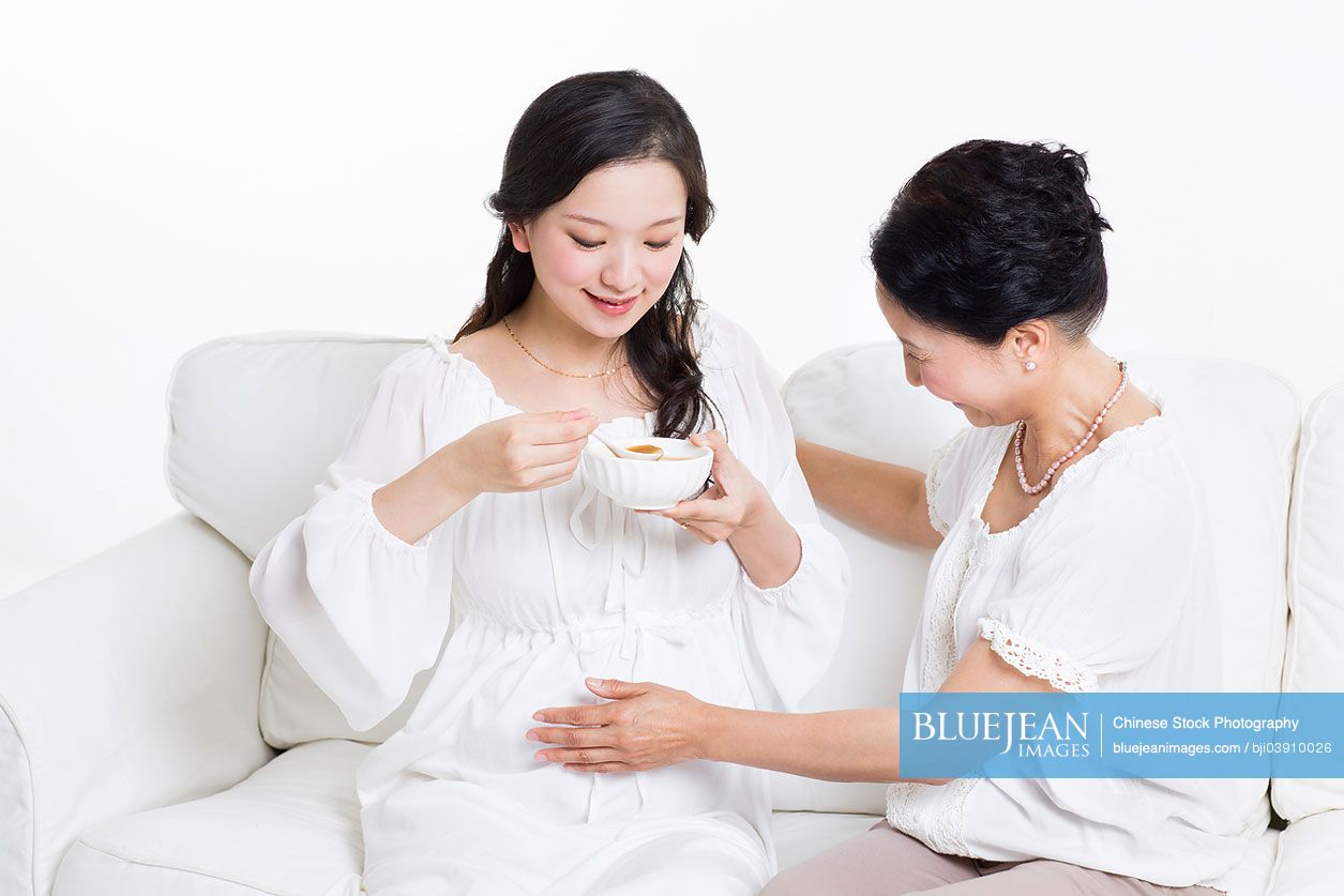Senior Chinese woman taking care of pregnant woman
