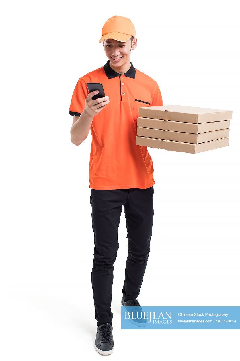 Cheerful Chinese pizza delivery person holding a smart phone